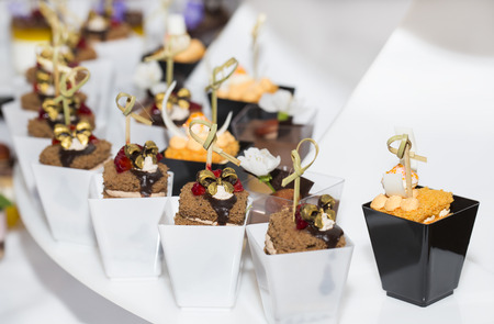 mini canapes in plastic cups decorated with edible flowersの写真素材