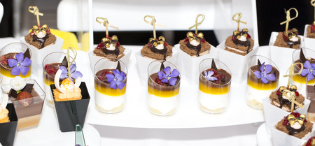 mini canapes in plastic cups decorated with edible flowers