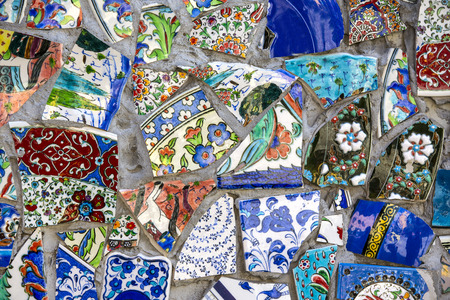 wall with broken ceramic plates colored fragmentsの写真素材