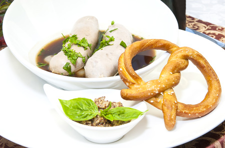 sausages in beer sauce with mustard and pastriesの写真素材