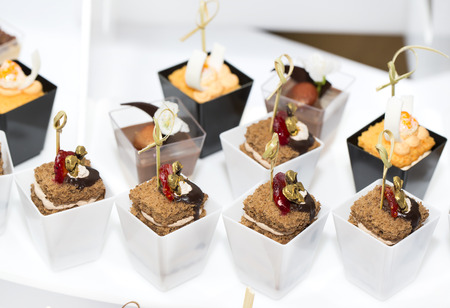 canapes in plastic cups decorated with edible flowersの写真素材