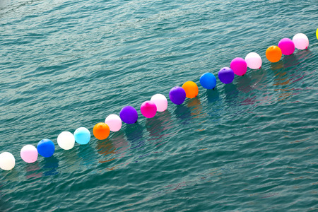 colorful balloons on the water are placed in a row