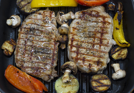 Cooking steak and vegetables on grill pan