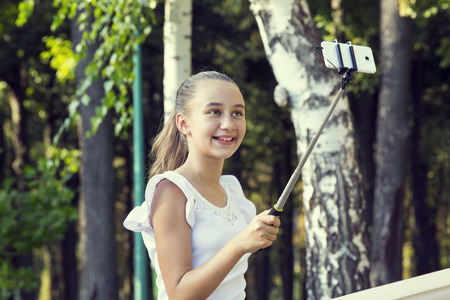 girl doing selfie phone in a summer parkの写真素材
