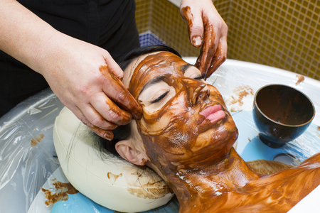 Process chocolate mask Woman in a beauty salonの写真素材