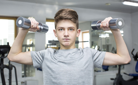 Teenage boy engaged in the gym hallの写真素材