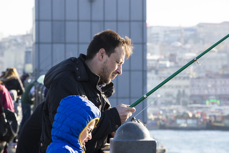 ISTANBUL, TURKEY - 1 APRIL, 2017: Fishermen on the Galata Bridge fish in the Golden Horn Bay Turkeyのeditorial素材