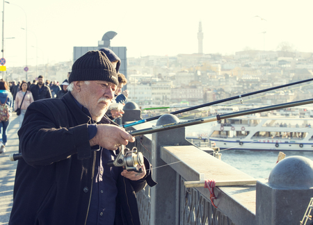 ISTANBUL, TURKEY - 1 APRIL, 2017: Fishermen on the Galata Bridge fish in the Golden Horn Bay Turkeyのeditorial素材