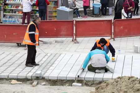 STANBUL, TURKEY - 4 APRIL 2017: Road workers repair the sidewalk in Istanbul near the Galata Bridgeのeditorial素材