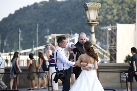 BUDAPEST, HUNGARY. 23 JUNE, 2017: A group of wedding photographers on the streets of Budapest is holding a photo session for a couple of newlyweds.のeditorial素材