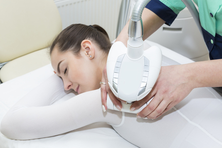 The procedure of lipomassage in a beauty salon makes a womanの写真素材