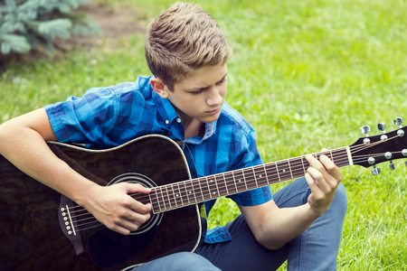Young sad guy with an acoustic guitarの写真素材