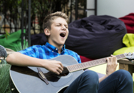 Young sad guy with an acoustic guitarの写真素材