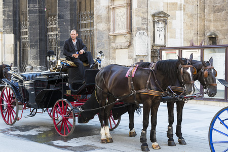 VIENNA, AUSTRIA - 23 AUGUST 2017: Traditional horse-drawn carriages with cabs for tourists to walk along the ancient streets of Vienna.のeditorial素材