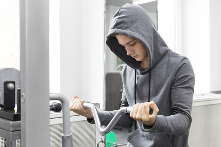 The teenager is engaged in power fitness in the gym.