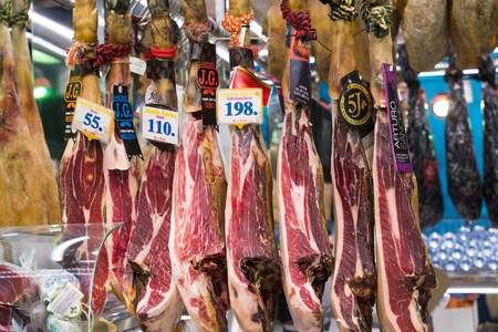 BARCELONA, SPAIN - 11 JANUARY 2018: Products on food shelves in the oldest market of Barcelona Boqueria selling food jamon vegetables for tourists and visitors to the city.のeditorial素材