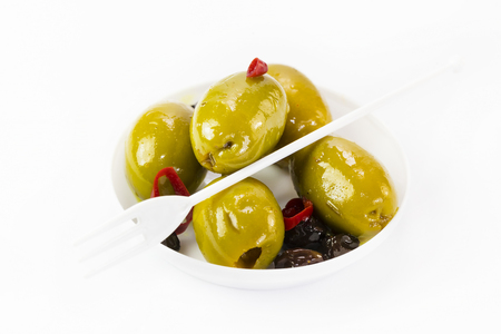 Olives in a small plastic plate on a white background.の写真素材