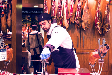 BARCELONA, SPAIN - 11 JANUARY 2018: The old grocery market of Barcelona Boqueria selling food jamon vegetables for tourists and visitors to the city.のeditorial素材
