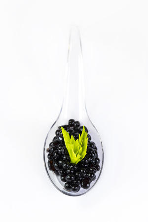 Plastic spoons with fish caviar on a white background.の写真素材