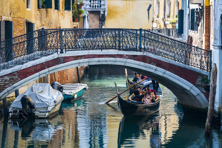 ITALY, VENICE - 5 SEPTEMBER, 2018: Men in gondoliers with tourists in Venice in Italy.のeditorial素材