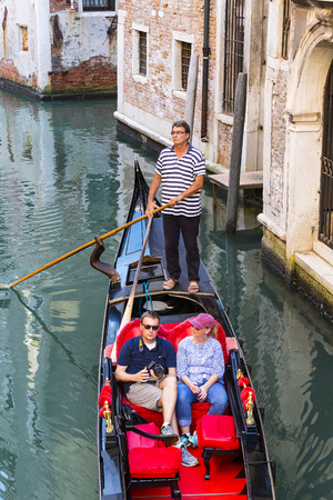 ITALY, VENICE - 5 SEPTEMBER, 2018: Men in gondoliers with tourists in Venice in Italy.のeditorial素材