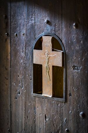 Wooden door with a metal crucifix of Jesus Christ.の写真素材