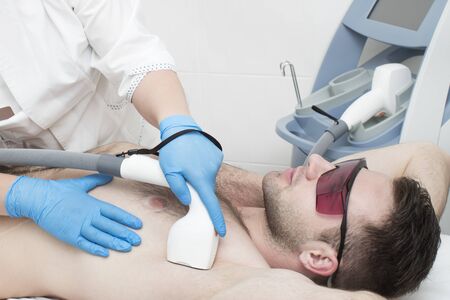 Laser hair removal procedure for a man in a beauty salon.の写真素材