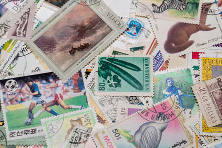 KHARKOV, UKRAINE - JUNE 23, 2020: Background of postage stamps used in different countries of the world shot closeup.のeditorial素材