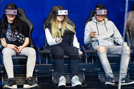 Unidentified female gamers play a game with virtual reality headsets.