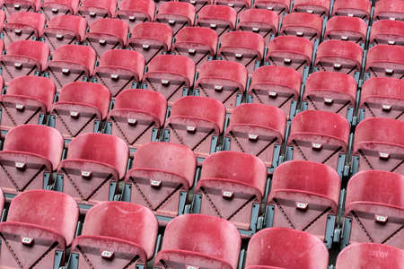 Rows of red seats in an empty stadium. Abstract background.