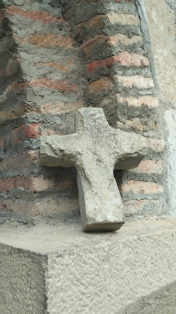 stone Christian cross at the walls of a stone Christian churchの写真素材