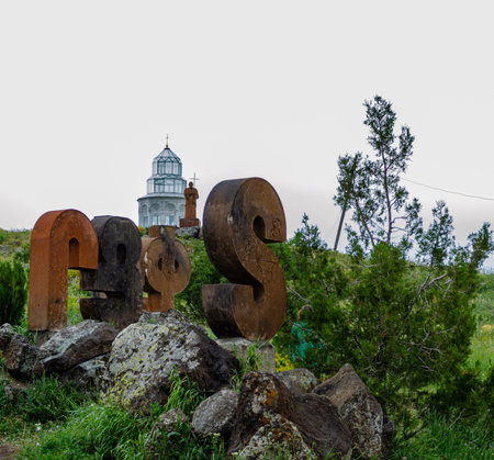 Old stone letters with the church on the background of green forest.の写真素材