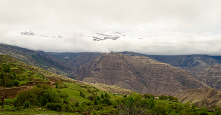Panoramic view of the cloud-covered mountains in a green valley