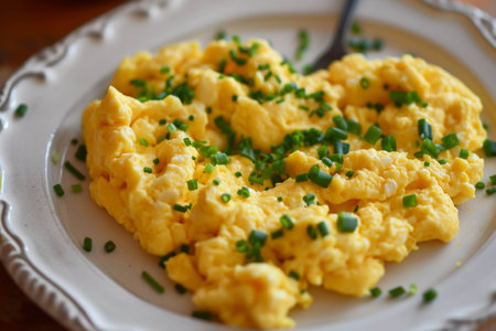 Scrambled egg in shape of heart on white plate top viewの素材