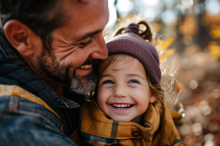 Dad hugging his little daughter in the park-father and daughter outdoors smiling face to faceの素材