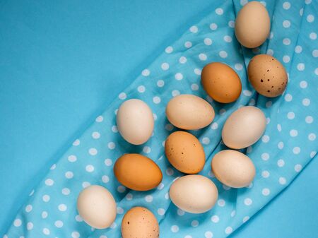 Organic chicken eggs on a blue background, with space for text, top view.の写真素材