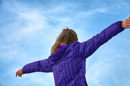 Happy girl with arms outstretched.の写真素材