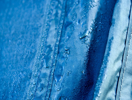 Water drops on waterproof membrane fabric. Detail view of texture of blue synthetic waterproof cloth. Morning dew on tent.の写真素材