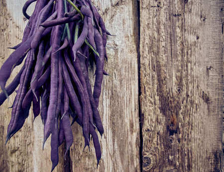 Purple asparagus beans on a wooden background.の写真素材