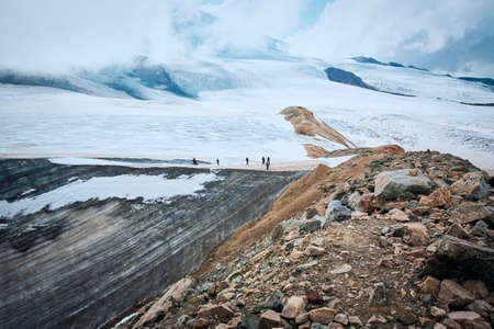 A group of hikers ascending a snowing mountain in sunny winter morningの写真素材