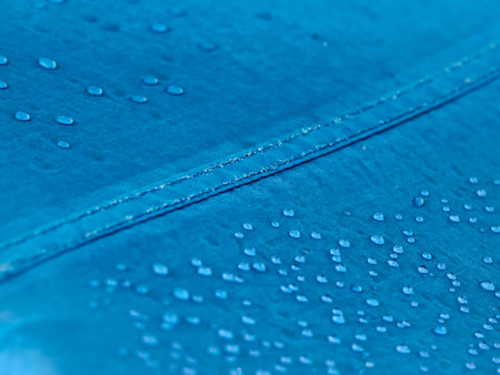 Water drops on waterproof membrane fabric. Detail view of texture of blue synthetic waterproof cloth. Morning dew on tent.の写真素材