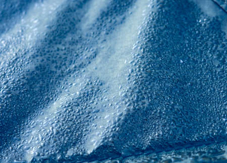 Water drops on waterproof membrane fabric. Detail view of texture of blue synthetic waterproof cloth. Morning dew on tent.の写真素材