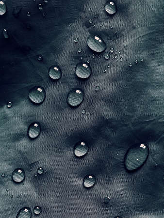 Water drops on waterproof membrane fabric. Detail view of waterproof cloth.の写真素材