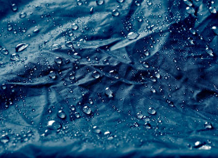 Water drops on waterproof membrane fabric. Detail view of texture of blue waterproof cloth.の写真素材