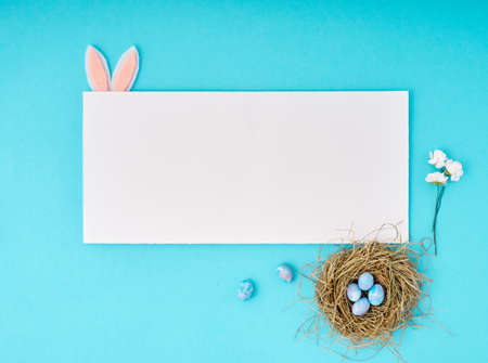 Easter greeting card with copy space. Paper blank on blue background.の写真素材