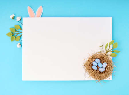 Easter greeting card with copy space. Paper blank on blue background.の写真素材