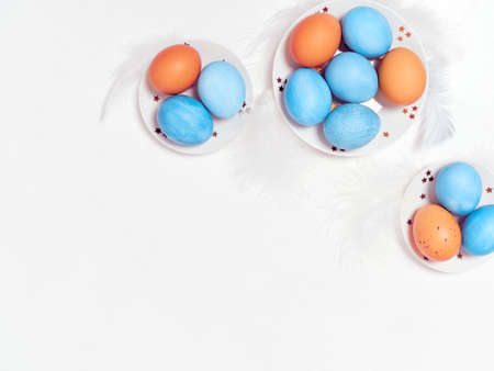 Colored eggs on plate with on white background. Flat lay. Copy space. Easter concept. Top view.の写真素材