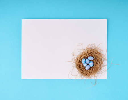 Easter greeting card with copy space. Paper blank on blue background.の写真素材