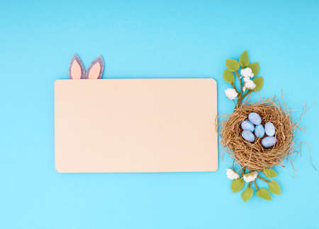 Easter greeting card with copy space. Paper blank on blue background.の写真素材