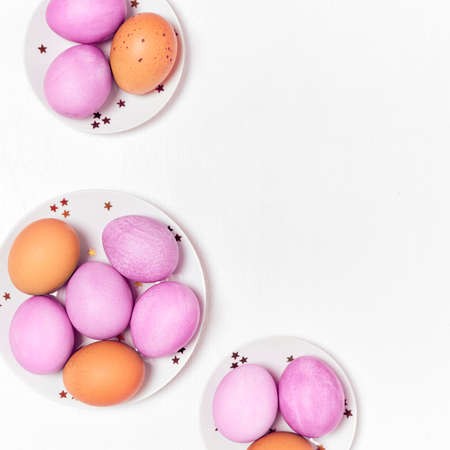 Colored eggs on plate with on white background. Flat lay. Copy space. Easter concept. Top view.の写真素材